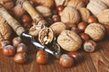 Whole and chopped walnuts and nutcracker on old wooden table