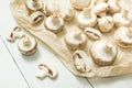 Whole and chopped white mushrooms on a white wooden background Royalty Free Stock Photo