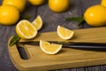 Whole citrus, sliced lemon slices and knife on cutting Board, on table