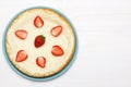 A whole classic cheesecake with strawberries on a white background. Top view Royalty Free Stock Photo