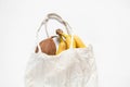 Whole coconut and bananas lie in a fabric grocery bag on a white background, fruits Royalty Free Stock Photo