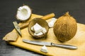 Whole coconut and broken with tools to open it on the board. Royalty Free Stock Photo
