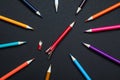 Whole colorful pencils and broken one on black background, flat lay. Bullying concept Royalty Free Stock Photo