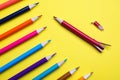 Whole colorful pencils and broken one on yellow background, flat lay. Bullying concept Royalty Free Stock Photo