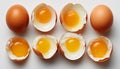 Whole and cracked open eggs with yolks on white surface