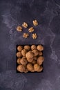 Whole and cracked walnuts on a square plate on blue textured surface, top view. Healthy nuts and seeds composition. Royalty Free Stock Photo
