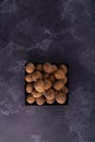 Whole and cracked walnuts on a square plate on blue textured surface, top view. Healthy nuts and seeds composition. Royalty Free Stock Photo