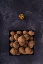 Whole and cracked walnuts on a square plate on blue textured surface, top view. Healthy nuts and seeds composition. Royalty Free Stock Photo