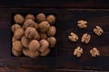 Whole and cracked walnuts on a square plate on wooden table, top view. Healthy nuts and seeds composition. Royalty Free Stock Photo