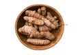 Whole curcuma roots in bowl. Fresh raw turmeric spice, isolated on white. Top view.