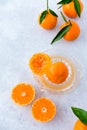 Whole and Cut Clementines with Leaves on Citrus Juicer and Background