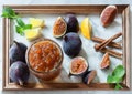 Whole and cut figs, with dish of homemade fig jam or marmalade kitchen marble table framed. Royalty Free Stock Photo