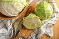 Whole and cut fresh cabbage on wooden table Royalty Free Stock Photo