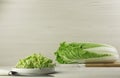 Whole and cut fresh ripe Chinese cabbage on table against white wooden background. Space for text Royalty Free Stock Photo