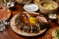 Whole cut fried fish with fresh herbs and lemon on a table for dinner. Whole meal, table covered with food Royalty Free Stock Photo