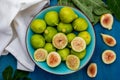 Whole and cut green figs, with fig leaves. Royalty Free Stock Photo