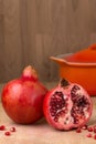 Whole & cut Pomegranate on wood chopping board Punica granatum