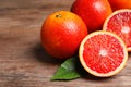 Whole and cut red oranges on wooden table, closeup Royalty Free Stock Photo