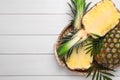 Whole and cut ripe pineapples on white wooden table, top view. Space for text Royalty Free Stock Photo