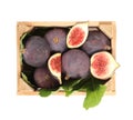 Whole and cut tasty fresh figs with green leaves in wooden crate on white background, top view Royalty Free Stock Photo