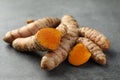 Whole and cut turmeric roots on grey table, closeup Royalty Free Stock Photo