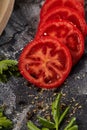 Whole and cutted tomato of pizza on italian black paper table Royalty Free Stock Photo