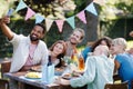 The whole family sitting at the table taking a group selfie at the family garden party. A family gathering to celebrate Royalty Free Stock Photo