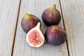 Whole figs and one fig sliced in half on top of a garden table. Royalty Free Stock Photo