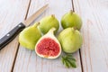 Whole figs and one fig sliced in half on top of a garden table. Royalty Free Stock Photo