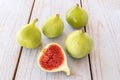 Whole figs and one fig sliced in half on top of a garden table. Royalty Free Stock Photo