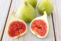 Whole figs and one fig sliced in half on top of a garden table. Royalty Free Stock Photo