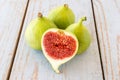 Whole figs and one fig sliced in half on top of a garden table. Royalty Free Stock Photo