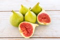 Whole figs and one fig sliced in half on top of a garden table. Royalty Free Stock Photo