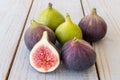 Whole figs and one fig sliced in half on top of a garden table. Royalty Free Stock Photo