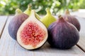 Whole figs and one fig sliced in half on top of a garden table. Royalty Free Stock Photo