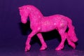 a whole figure of a pink horse on a purple background