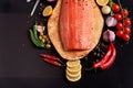 A whole filet with a piece of green and red chili peppers, lemon, peas, garlic, cherry tomatoes on a sprig, onions and rosemary, g Royalty Free Stock Photo