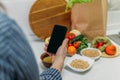 Whole-food, plant-based diet for boost health. Female hand cell phone with Plant-Based Menu recipes and healthy meal Royalty Free Stock Photo