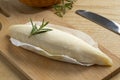 Whole French Bouyguette cheese on a cutting board close up