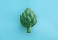 Whole fresh raw artichoke on light blue background, top view Royalty Free Stock Photo