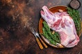 Whole fresh Raw goat shoulder meat on a plate. Dark wooden background. Top view. Copy space Royalty Free Stock Photo