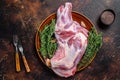 Whole fresh Raw lamb shoulder meat on a plate. Dark wooden background. Top view Royalty Free Stock Photo