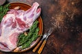 Whole fresh Raw lamb shoulder meat on a plate. Dark wooden background. Top view. Copy space Royalty Free Stock Photo