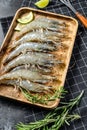 Whole fresh raw tiger prawns, shrimp on a wooden tray. Black background. Top view Royalty Free Stock Photo