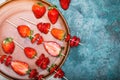 Whole fresh red strawberries and sliced strawberries on wooden skewers in ceramic plate Royalty Free Stock Photo