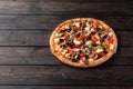 Whole fresh round pizza with chicken meat, vegetables, mushrooms and cheese close-up on a wooden brown table Royalty Free Stock Photo