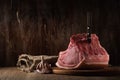 a whole freshly cut piece of raw pork loin lies on a cutting board with a knife, burlap and garlic a brown wooden background. side Royalty Free Stock Photo