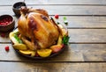 Whole fried chicken with fruits and potatoes close up