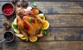 Whole fried chicken with fruits and potatoes close up