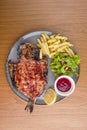 Whole fried fish Dorado divided into halves opened with garnish potatoes sauce salad and lemon Royalty Free Stock Photo